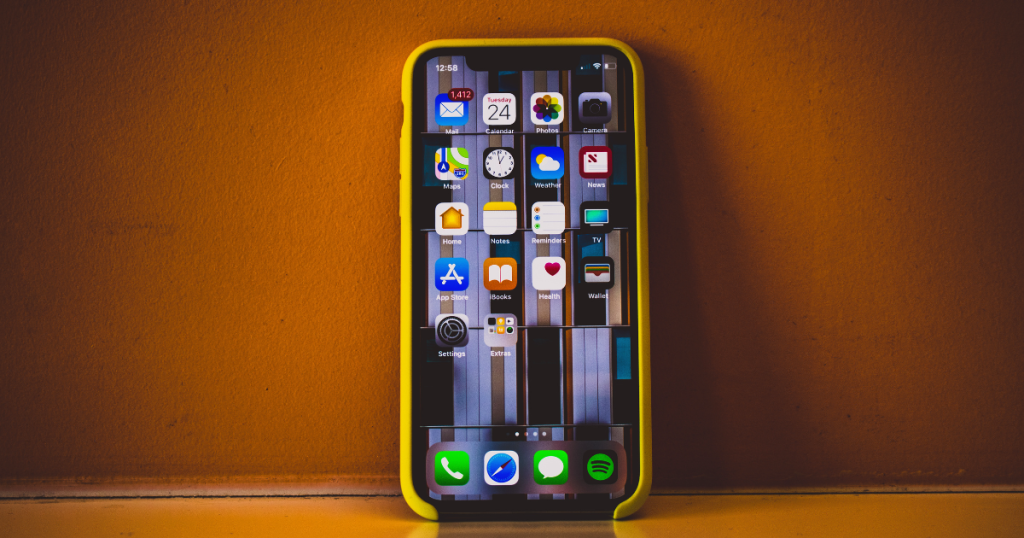 sur fond terracotta un iphone d'Apple allumé avec IOS18 et son intelligence artificielle